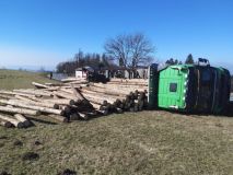 Obrazem: Plně naložený nákladní automobil se sdřevem si lehnul na bok a dřevo se rozsypalo kolem