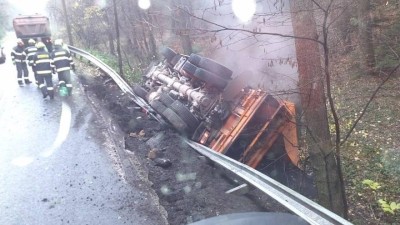 Nákladní auto převážející asfalt se převrátil na střechu do příkopu v blízkosti potoka